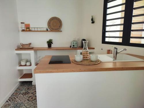 - une cuisine avec un comptoir en bois et un évier dans l'établissement T2 Villa Rêve d'ailleurs St Leu, à Saint-Leu