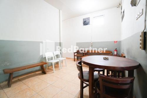 a dining room with tables and chairs in a room at Bright Residence near ITC Mangga Dua Mitra RedDoorz in Jakarta