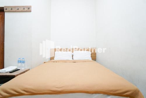 a bedroom with a bed and a table with a phone at Bright Residence near ITC Mangga Dua Mitra RedDoorz in Jakarta