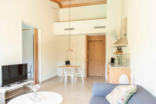 a living room with a blue couch and a kitchen at Can Alemany in Santa Margarida de Montbui