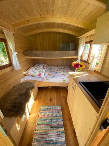 einen Blick ins Innere eines winzigen Hauses mit einem Etagenbett in der Unterkunft Schäferwagen Altensteig in Altensteig
