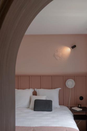 a bedroom with a large white bed with a light at Hôtel Le Prieuré in Paray-le-Monial