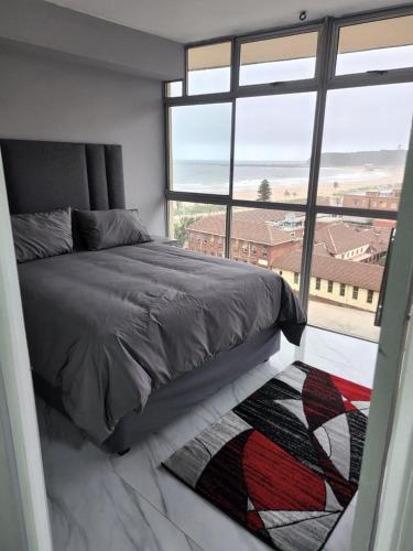 a bedroom with a bed and a large window at Sea Views at 10 South in Durban