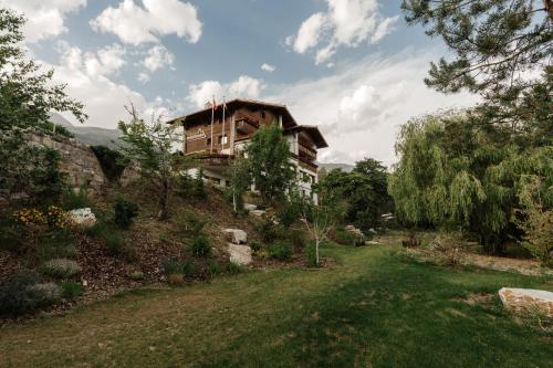 a house on top of a hill with a yard at Boutique Hotel Panorama in Crans-Montana