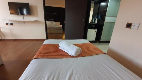 a bedroom with a bed with a white pillow on it at The Jerai Hotel Sungai Petani in Sungai Petani