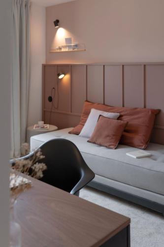 a living room with a bed and a couch at Hôtel Le Prieuré in Paray-le-Monial