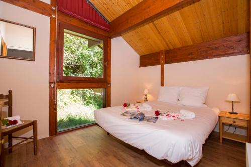 sypialnia z dużym łóżkiem w pokoju z oknami w obiekcie Chalet Résidence Chantey Mourry 67 - Happy Rentals w Chamonix-Mont-Blanc