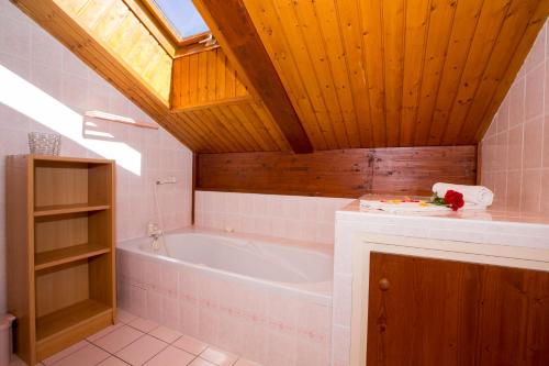 a bathroom with a bath tub and a wooden ceiling at Chalet Résidence Chantey Mourry 67 - Happy Rentals in Chamonix-Mont-Blanc