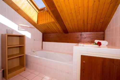 bagno con vasca e soffitto in legno di Chalet Résidence Chantey Mourry 67 - Happy Rentals a Chamonix-Mont-Blanc