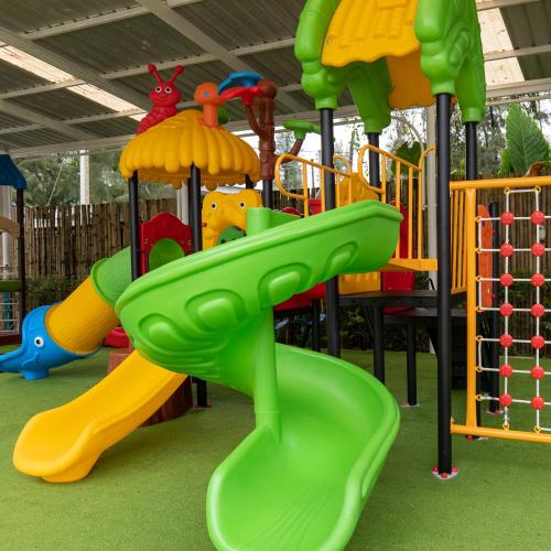 a playground with a green slide in a playground at Arinara Beach Resort Phuket - SHA Extra Plus in Bang Tao Beach