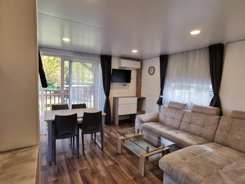 a living room with a couch and a table at Seecamping Berghof - Mobilheime in Landskron
