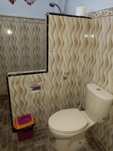 a bathroom with a toilet and a shower at Juda Homestay in Banyuwangi