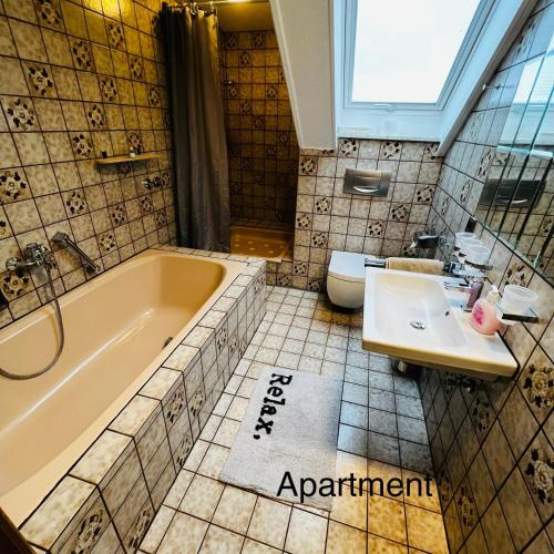 a bathroom with a tub and a sink and a toilet at Haus Löhrberg in Hemer