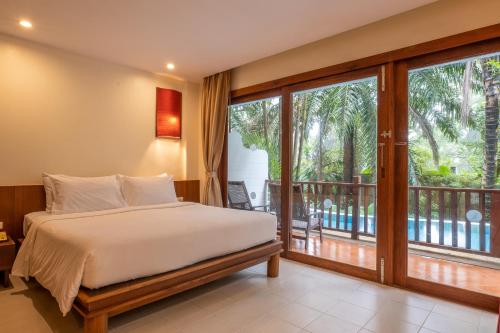 a bedroom with a bed and a balcony at Arinara Beach Resort Phuket - SHA Extra Plus in Bang Tao Beach