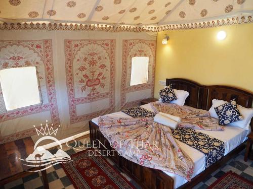 a bedroom with two beds and two windows at Queen of Thar Desert Camp in Sām