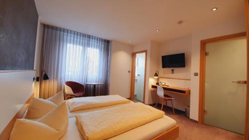ein Hotelzimmer mit einem Bett und einem Schreibtisch in der Unterkunft Hotel Restaurant Adler in Immenstaad am Bodensee