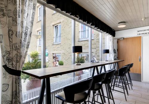 einen langen Tisch in einem Zimmer mit einem großen Fenster in der Unterkunft Østergaards Hotel in Herning