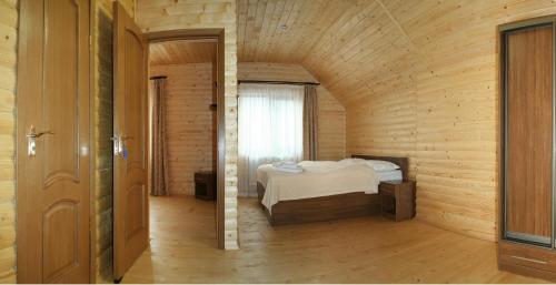 a bedroom with a bed in a wooden room at Proskurov Holiday Home in Bukovel
