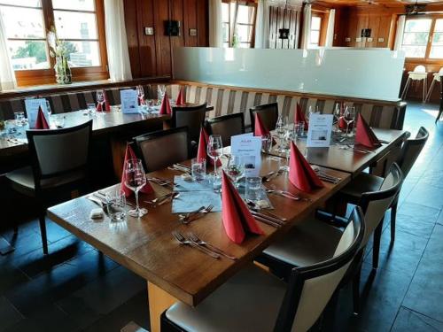 einen langen Tisch in einem Restaurant mit roten Servietten drauf in der Unterkunft Hotel Restaurant Adler in Immenstaad am Bodensee