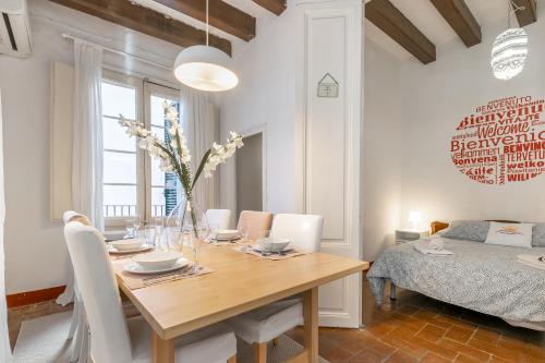 a dining room with a wooden table and a bed at Vistamar 2: Primera línea de mar con gran terraza in Sitges