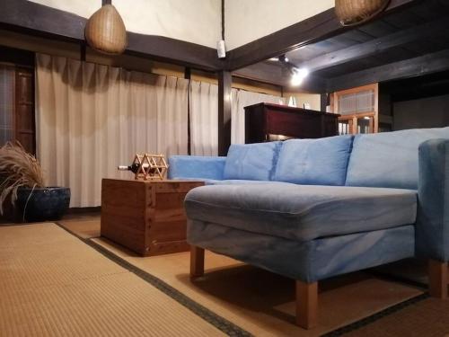 a living room with a blue couch and a table at Twinkle Villa in Kokuryō