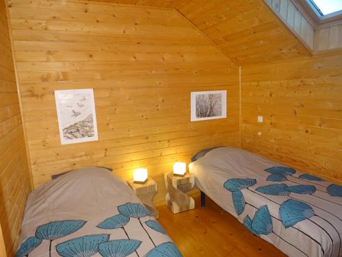 - une chambre avec 2 lits dans une cabane en rondins dans l'établissement Chalet douillet au cœur du Champsaur, à Poligny