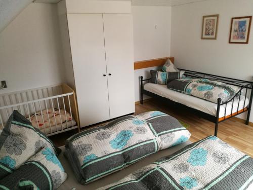 a bedroom with two twin beds and a crib at C1 Schwarzwald-Fewo an der Alb 50m FerienwohnungApp für max 5 Personen in Menzenschwand
