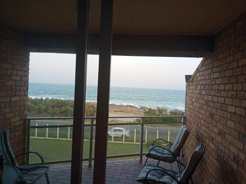 a porch with chairs and a view of the ocean at Astove 6 in Margate