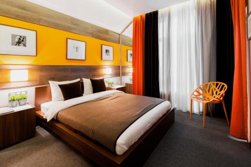 コロムナにあるAeroclub Alpina Aviaのベッドルーム1室(オレンジ色の壁の大型ベッド1台付)