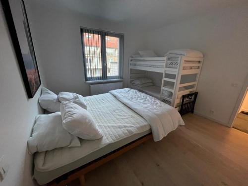 a bedroom with two bunk beds and a window at Maison les Bruyères in Blankenberge