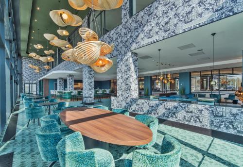 a lobby with a wooden table and chairs at Van der Valk Hotel A4 Schiphol in Hoofddorp