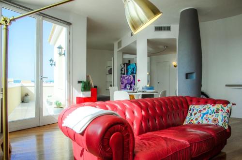 a red couch in a living room with a red at Casa Afrodite Exclusive Penthouse in Syracuse