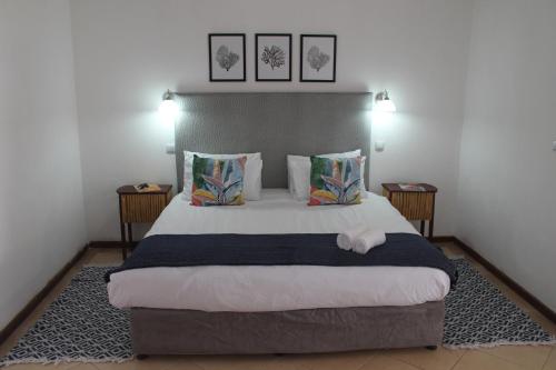 ein Schlafzimmer mit einem großen Bett mit zwei Kissen in der Unterkunft Wharf Side Inn in Pemba