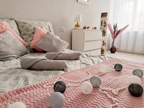 Un dormitorio con una manta rosa en una cama en Apartament Celebrity en Leśna