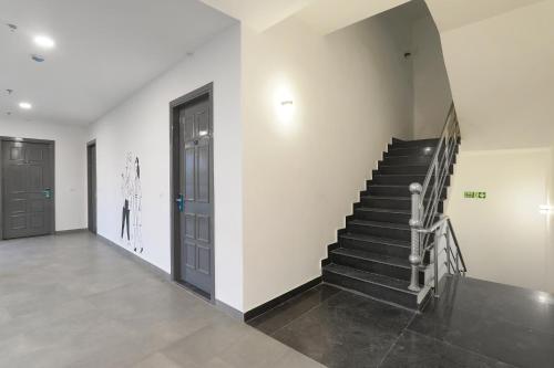 a hallway with a staircase and a door and a stair case at FabHotel BSA in Lucknow