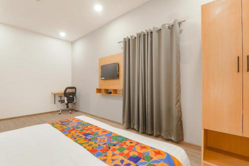 a bedroom with a bed and a tv in it at FabHotel BSA in Lucknow