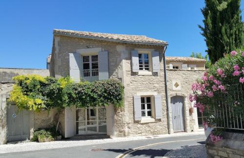ein Steinhaus mit Blumen vor einer Straße in der Unterkunft Luxury Village House In The Heart St.Remy-De-Provence in Saint-Rémy-de-Provence
