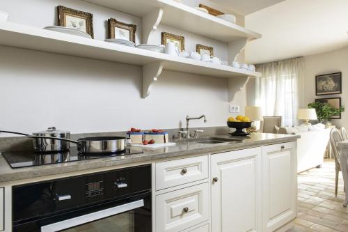 eine Küche mit weißen Schränken und einer Arbeitsplatte in der Unterkunft Luxury Village House In The Heart St.Remy-De-Provence in Saint-Rémy-de-Provence