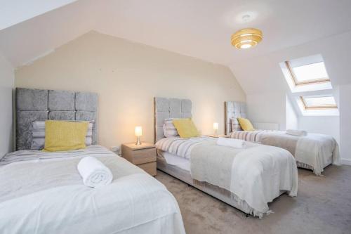 a bedroom with two beds with yellow pillows at TMS Cheerful 5BDR house! Thurrock! Free Parking! in Stanford-le-Hope