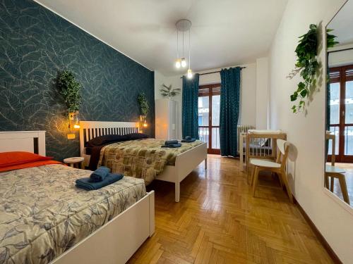 DEA DREAMS San Siro 27 Apartment في ميلانو: غرفة نوم بسريرين وغرفة طعام
