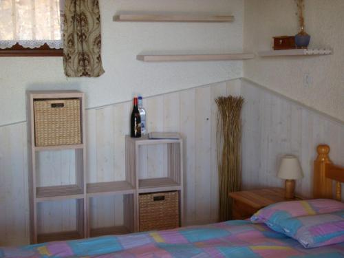 韋基奧港的聖塔露西的住宿－Maison Le Guetali，一间卧室配有一张床和一瓶葡萄酒