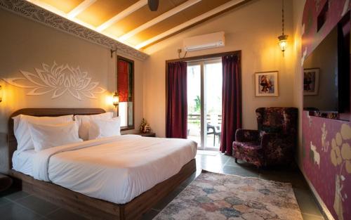 a bedroom with a bed and a chair and a window at Gandharv Resorts in Wai