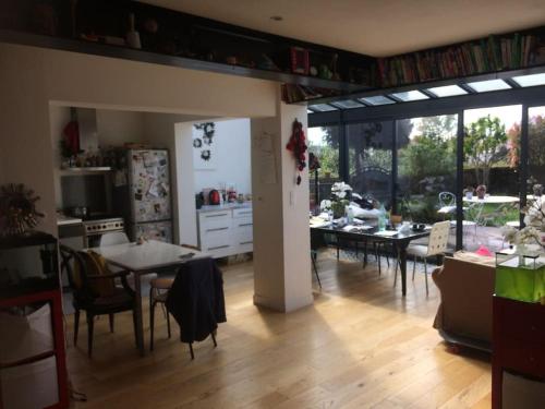 cocina y sala de estar con mesa y sillas en La maison sur la falaise en Nantes