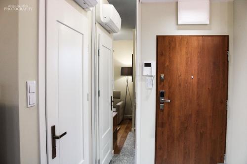 einen Flur, der zu einem Zimmer mit einer Tür führt in der Unterkunft D Apartments Centrum Woda in Białystok