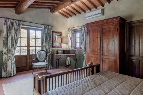 a bedroom with a bed and a desk and a chair at Borgo Vescine in Radda in Chianti