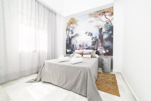 um quarto com uma cama com um quadro na parede em Maria´s Home em Málaga