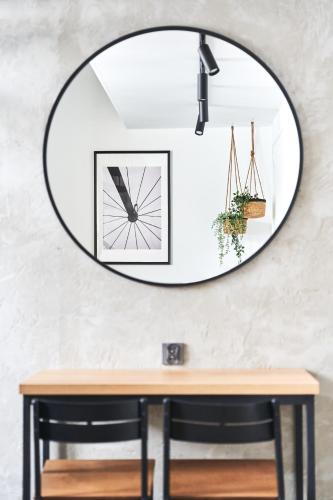a mirror hanging on a wall above a table at Na Fursie Apartments & Rooms in Nowy Targ