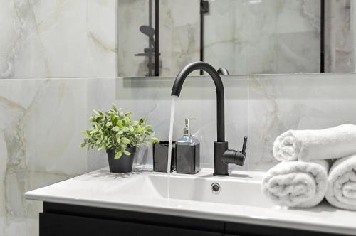 a bathroom sink with a faucet and towels at Modern renovated 1 bedroom apartment w Bomb Shelter Central TLV M2 in Tel Aviv