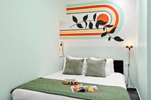a bed with a green blanket and a painting on the wall at Modern renovated 1 bedroom apartment w Bomb Shelter Central TLV M2 in Tel Aviv