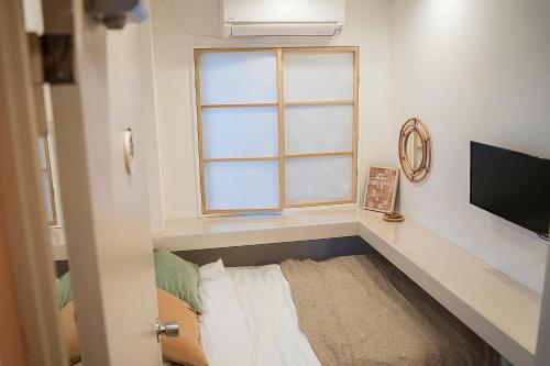 a room with a window and a bed and a television at Business Hotel Kankokukan in Tokyo